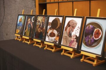 Six paintings displayed on a table in the Kitchener City Hall.