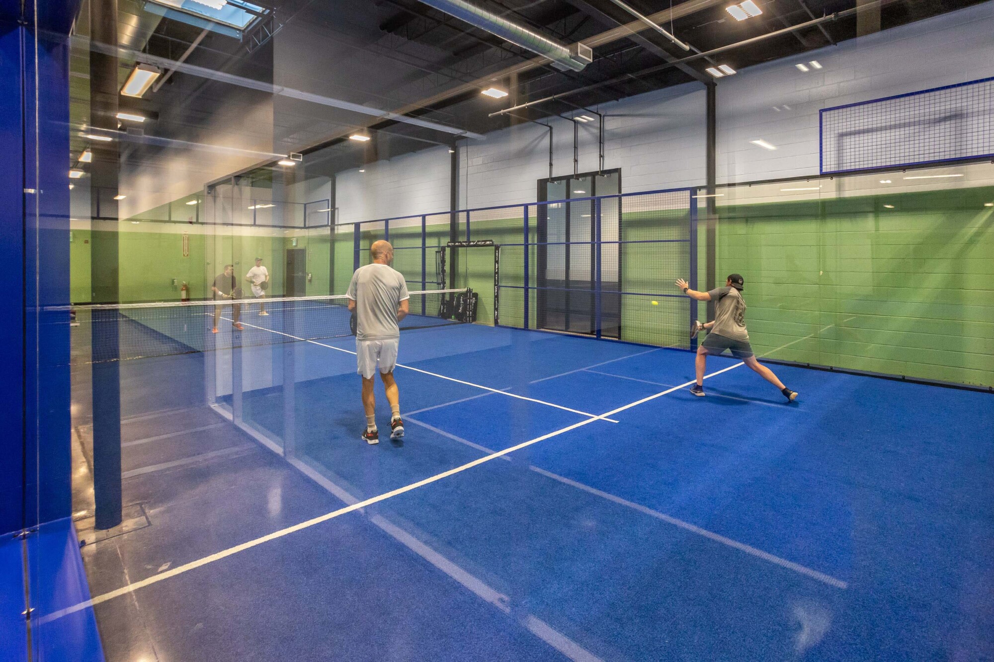 Photo of two platers in the middle of a padel match at Rookie + Ace athletic centre.