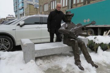 The statue of Mel Brown is sitting on a bench in Kitchener.