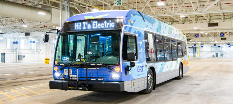 An electric bus from the Waterloo Region is parked on a street.
