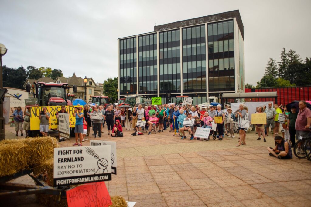 Photo of a crowd of people holding signs while attending the Fight for Farmland rally held in Wilmot Township on August 28th, 2024.