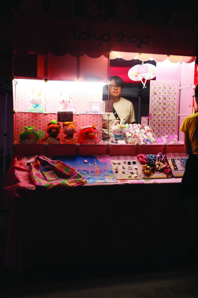 Photo of a vendor table at the Kitchener Far East Asian Night Market. The display is almost entirely pink and features numerous stuffed animals, stickers, scrunchies and fans.