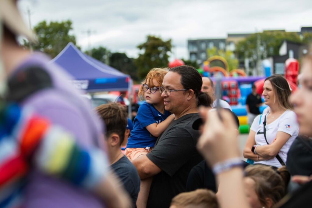 Photo of a child being held by a loved one at the Kitchener Ranger's preseason Fan Fest, held at the Kitchener Auditorium on September 1st, 2024.