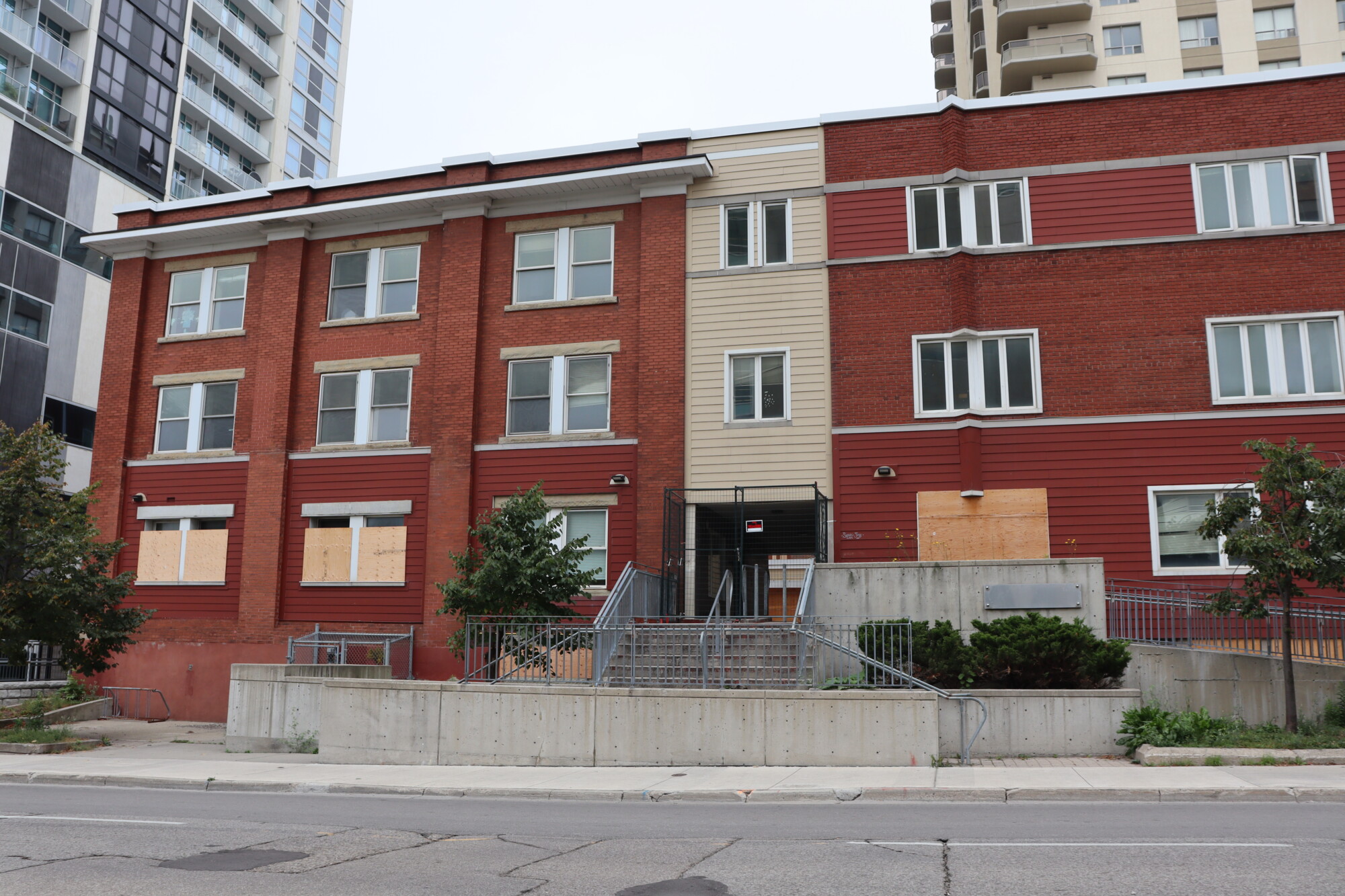 Photo of the former YWKW building at 84 Fredrick Street, now standing empty with plywood on the windows and a sign on the door.