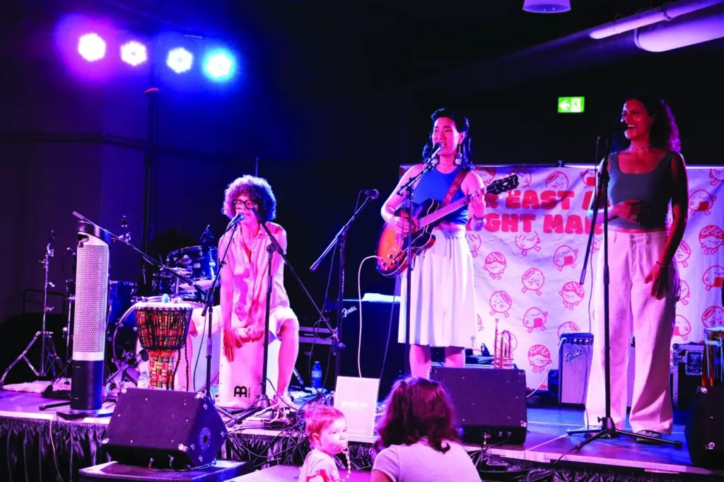 Photo of musician Janice Jo Lee performing on-stage with her band at the Kitchener Far East Asian Market, held on August 18th, 2024.